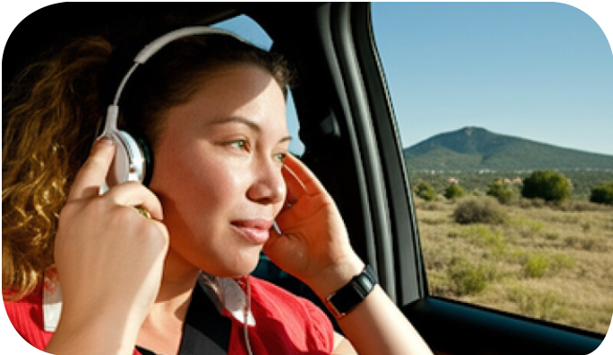 Woman in car using mobile audio tour with headphones